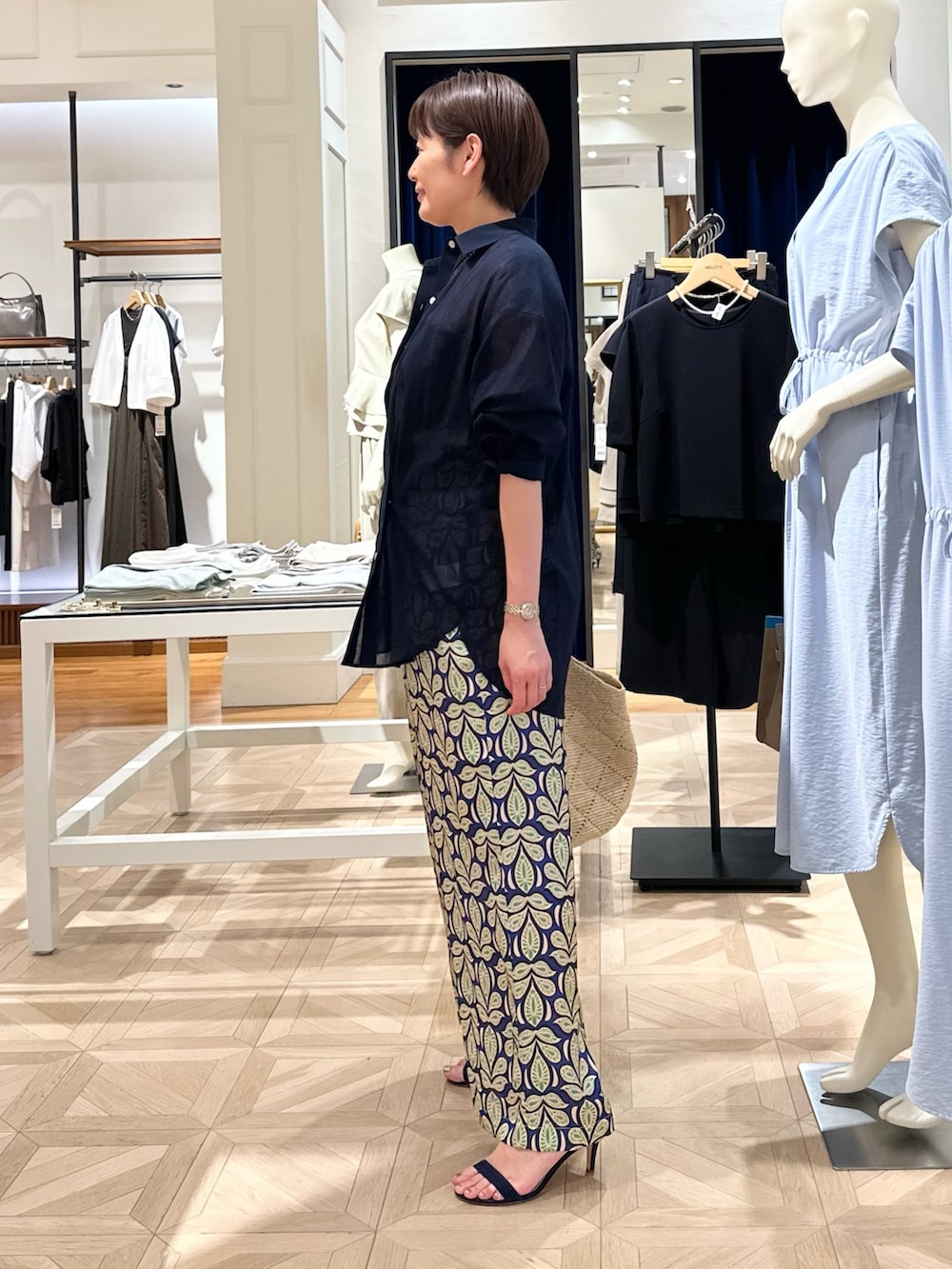 ブルー系のシャツ/ブラウス、グリーン系のその他パンツ、ベージュ系のかごバッグを着用したレディースの春コーディネートの2枚目の写真