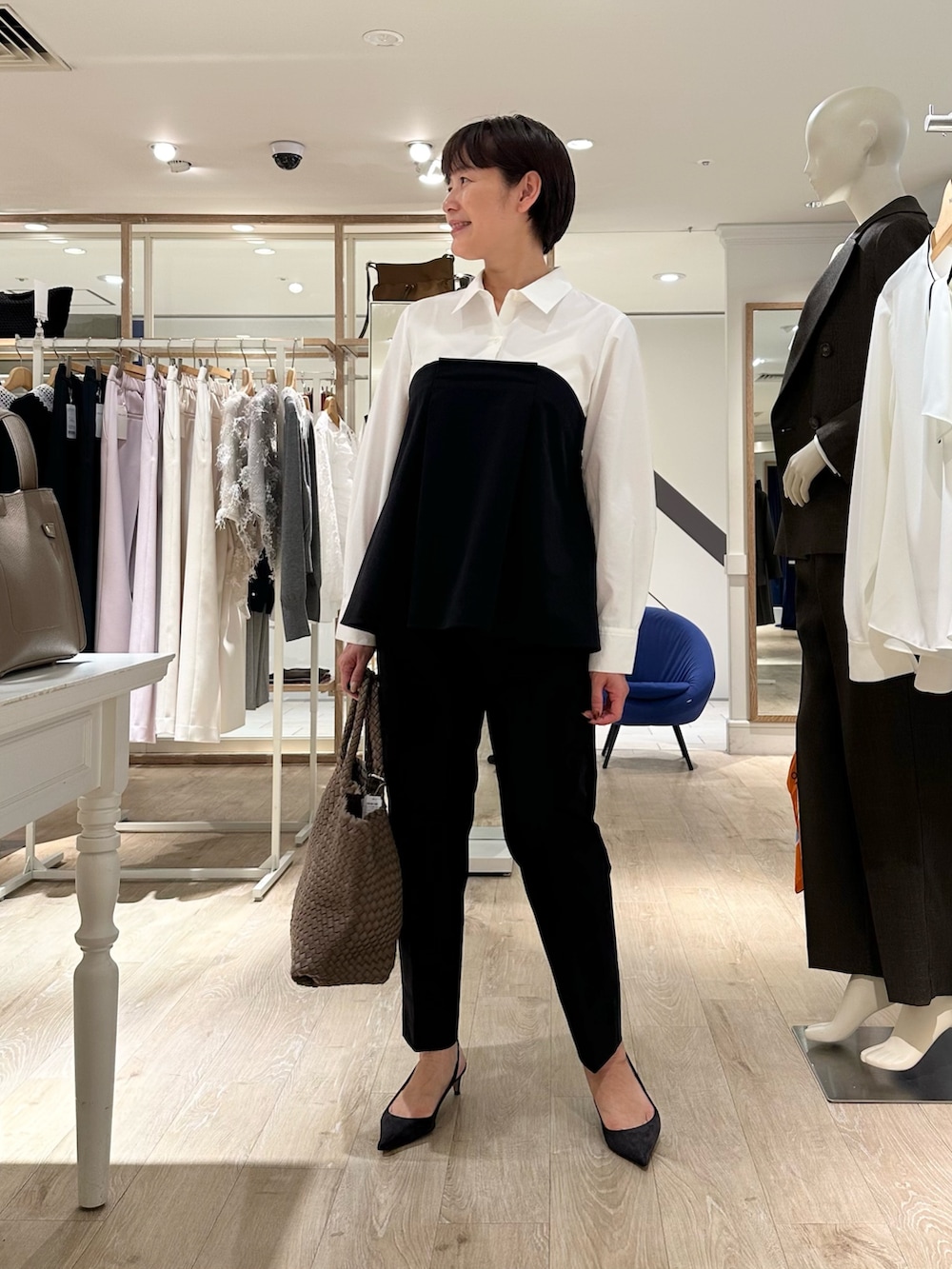 ブラック系のその他パンツ、ベージュ系のトートバッグ、ホワイト系のシャツ/ブラウスを着用したレディースの秋コーディネートの7枚目の写真