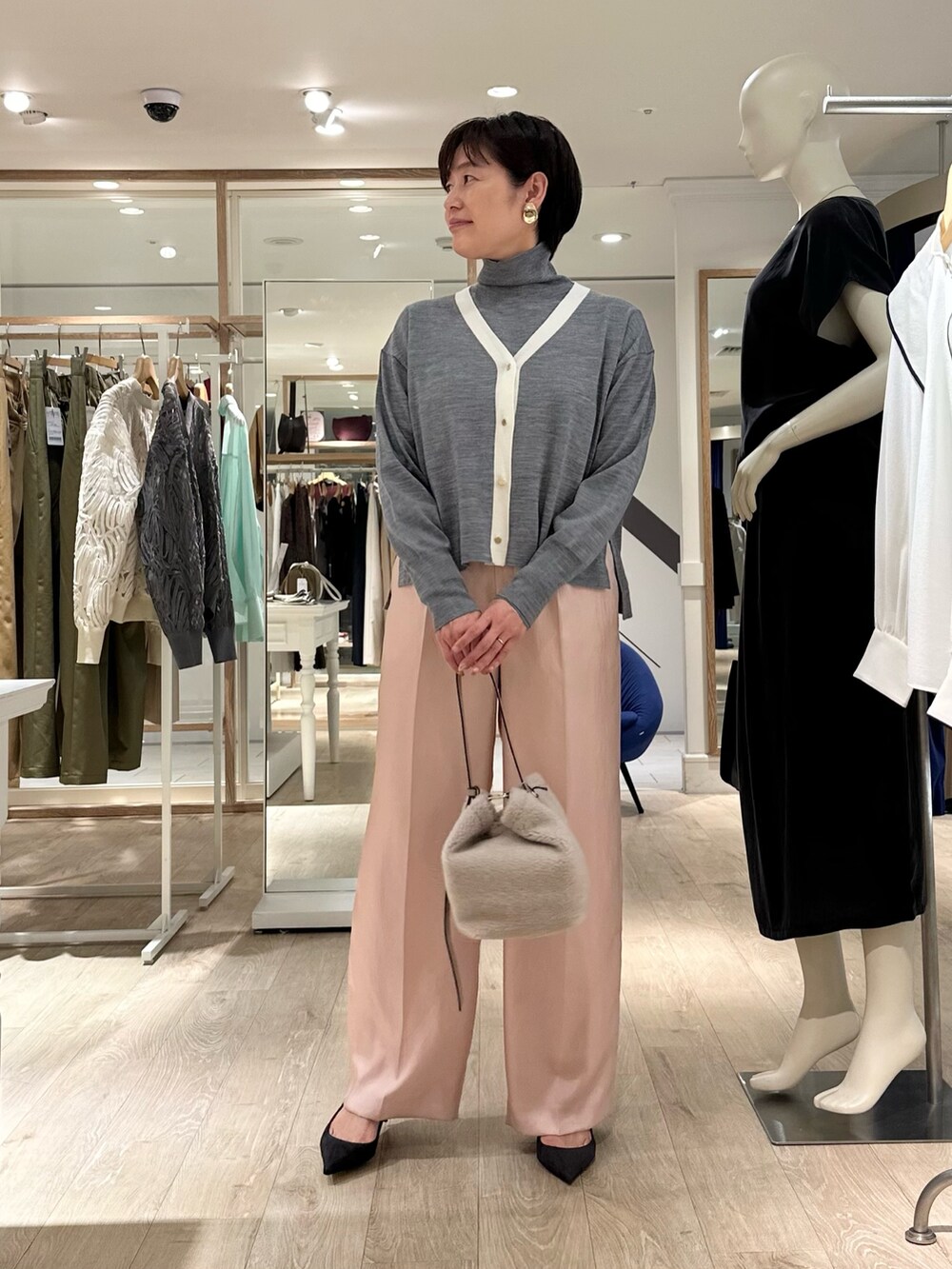 ベージュ系のショルダーバッグ、ピンク系のその他パンツ、グレー系のカーディガン/ボレロを着用したレディースの秋コーディネートの3枚目の写真