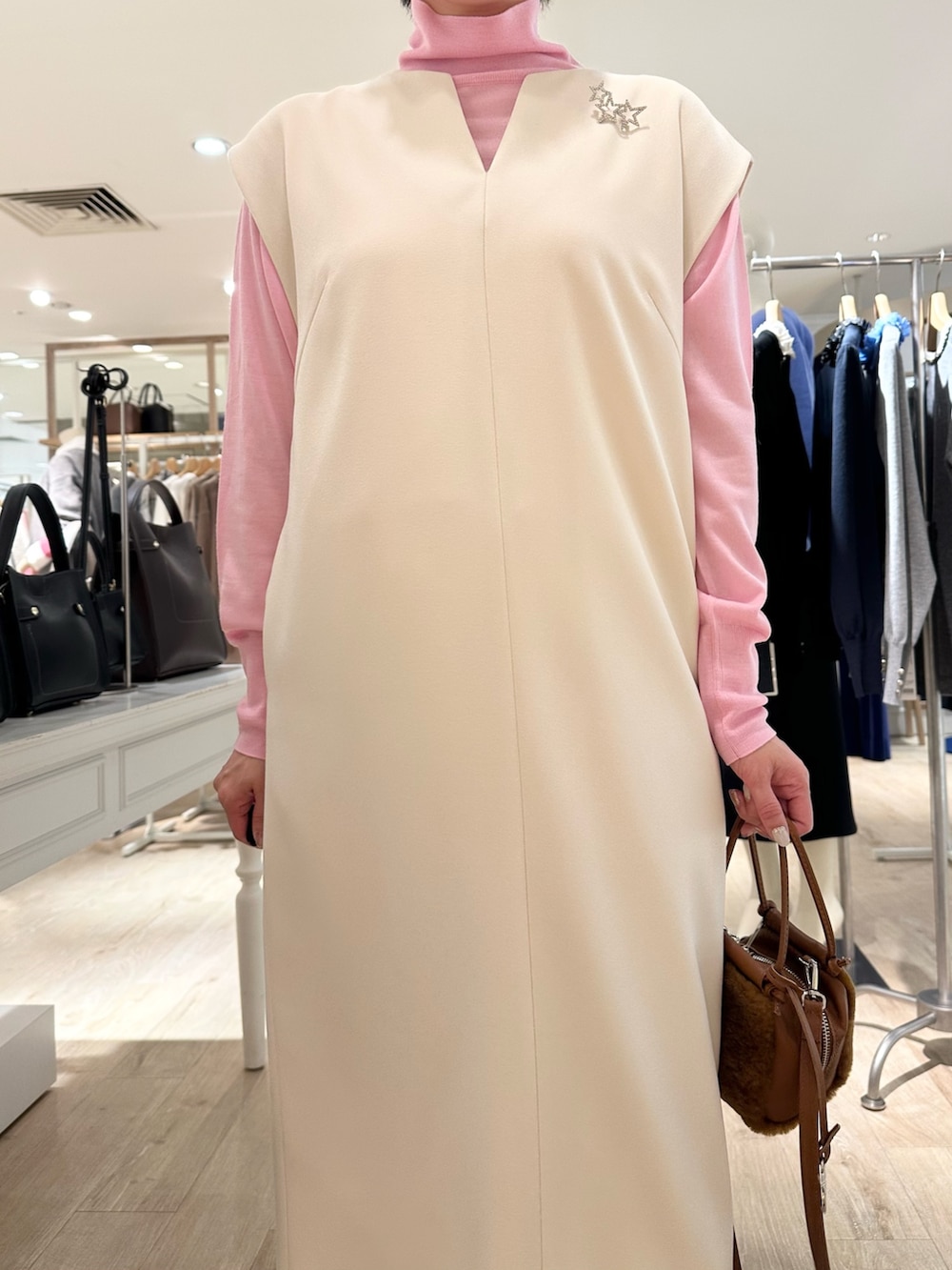 ブラック系のローファー、イエロー系のショルダーバッグ、ホワイト系のワンピースを着用したレディースの冬コーディネートの7枚目の写真