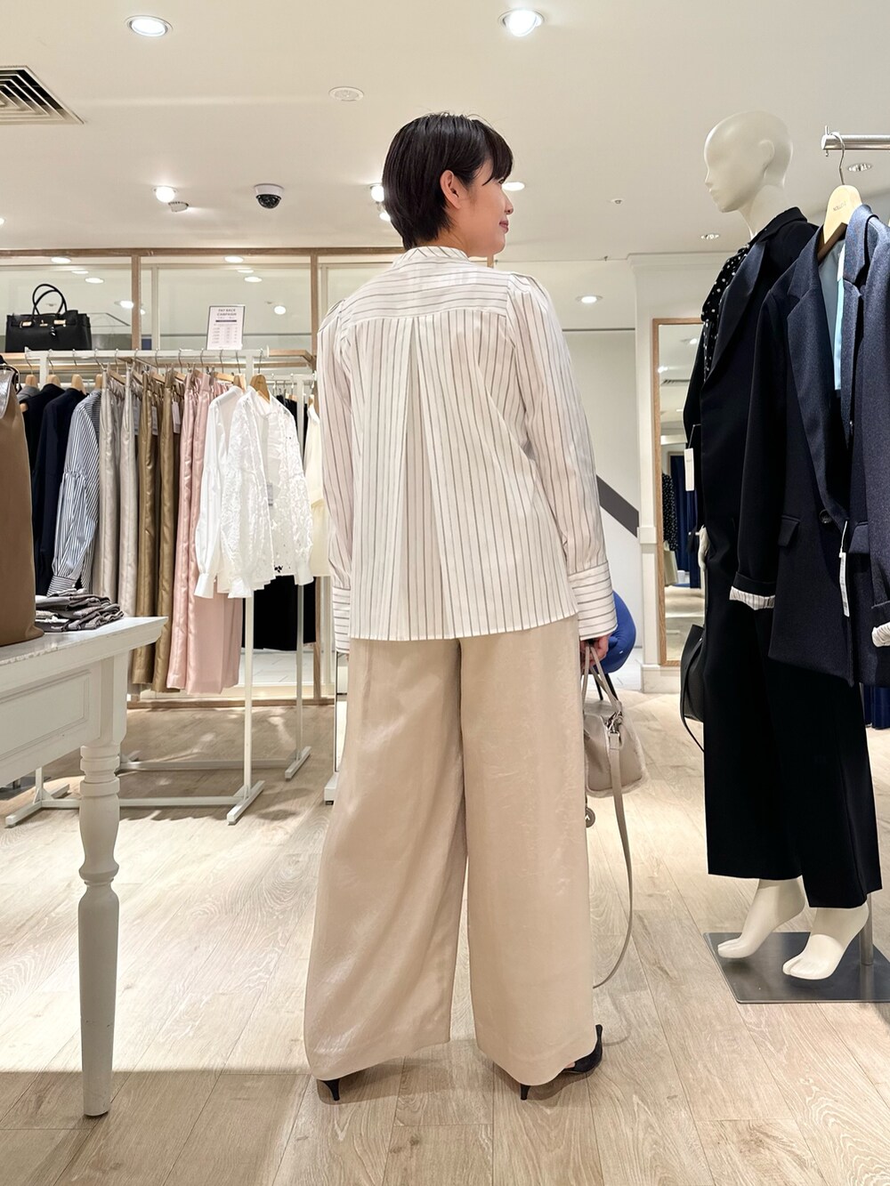 ホワイト系のシャツ/ブラウス、ベージュ系のショルダーバッグ、ベージュ系のその他パンツを着用したレディースの秋コーディネートの3枚目の写真