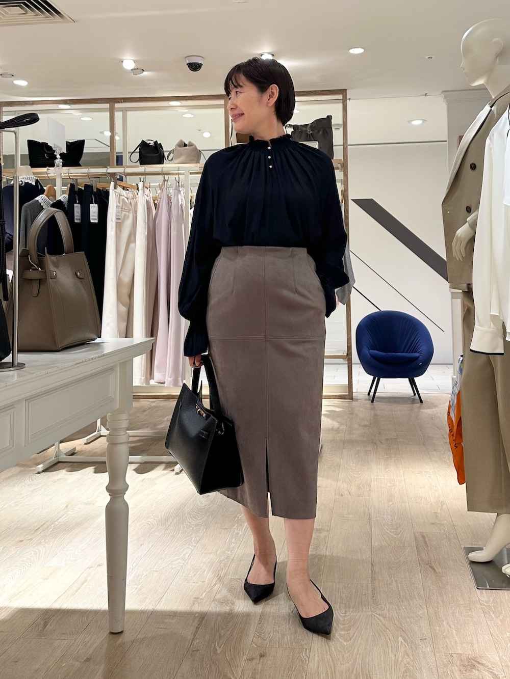 ブルー系のシャツ/ブラウス、グリーン系のスカート、ブラック系のショルダーバッグを着用したレディースの秋コーディネートの4枚目の写真