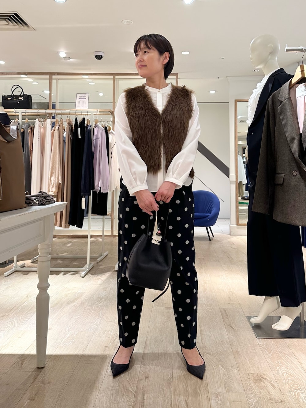 ブラック系のその他パンツ、ブラック系のショルダーバッグ、ホワイト系のシャツ/ブラウスを着用したレディースの秋コーディネートの2枚目の写真