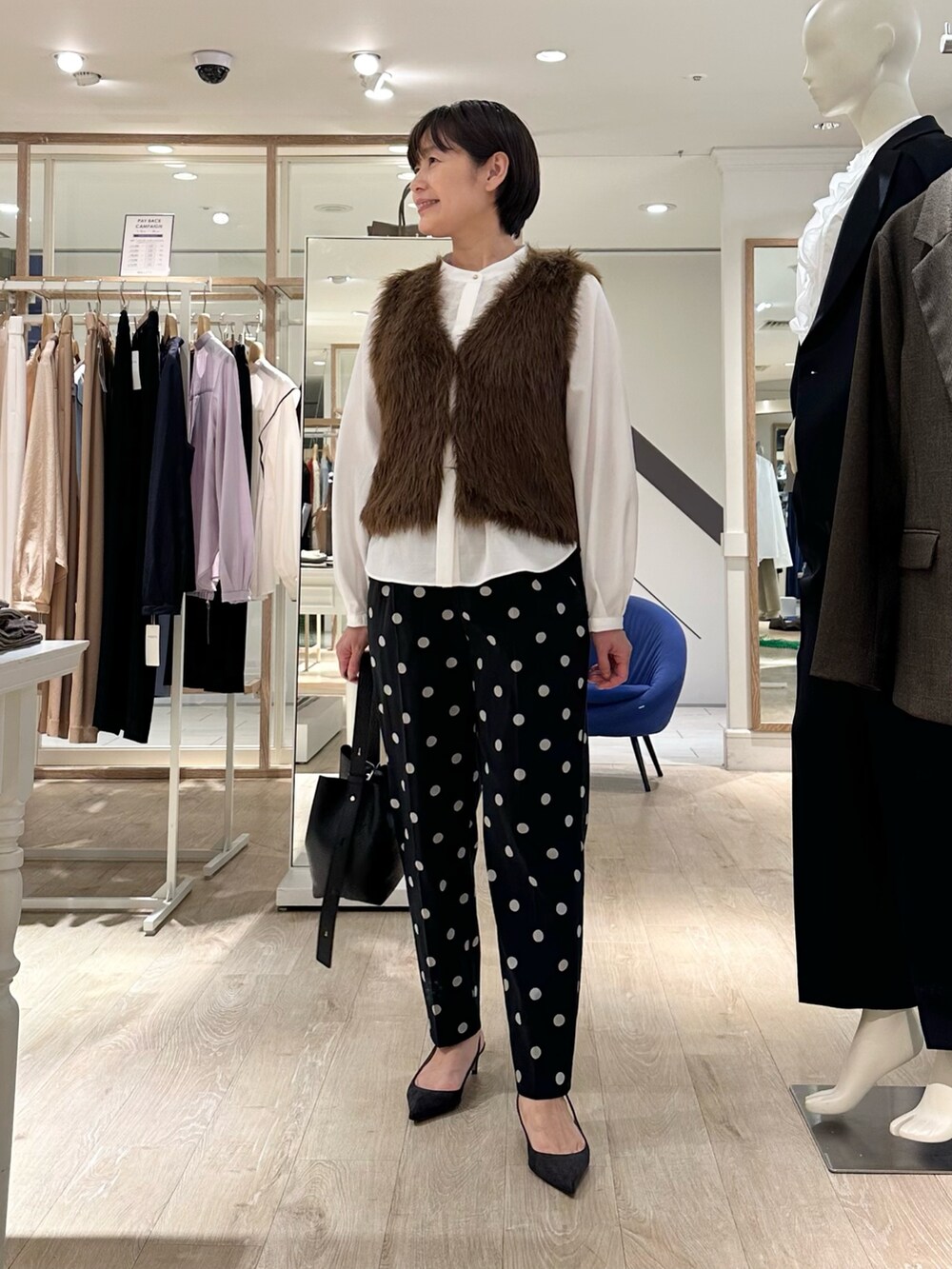 ブラック系のその他パンツ、ブラック系のショルダーバッグ、ホワイト系のシャツ/ブラウスを着用したレディースの秋コーディネートの6枚目の写真