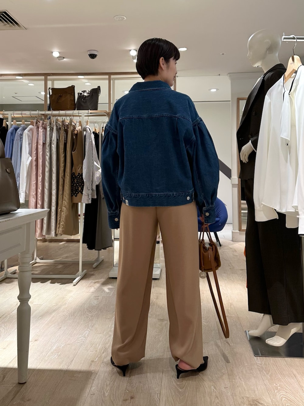 ブラック系のニット/セーター、イエロー系のショルダーバッグ、イエロー系のその他パンツを着用したレディースの秋コーディネートの3枚目の写真