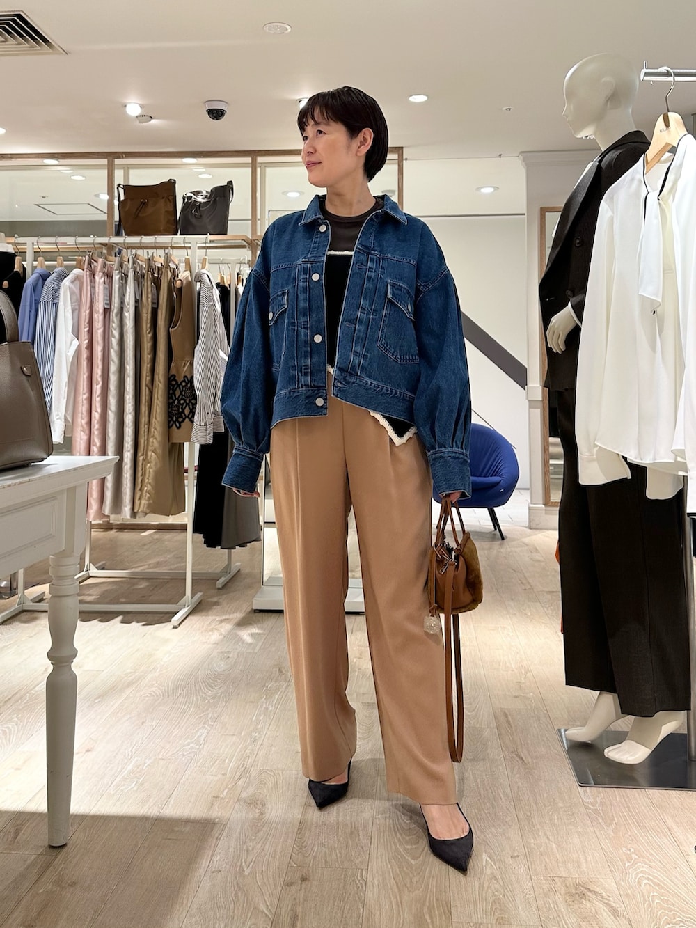 ブラック系のニット/セーター、イエロー系のショルダーバッグ、イエロー系のその他パンツを着用したレディースの秋コーディネートの7枚目の写真