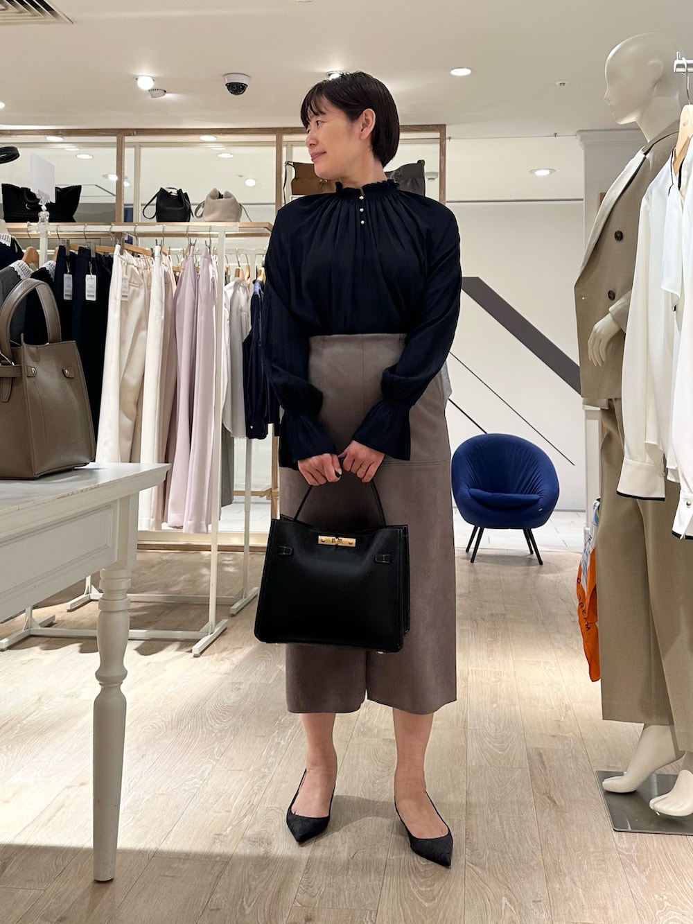 ブルー系のシャツ/ブラウス、グリーン系のスカート、ブラック系のショルダーバッグを着用したレディースの秋コーディネートの6枚目の写真