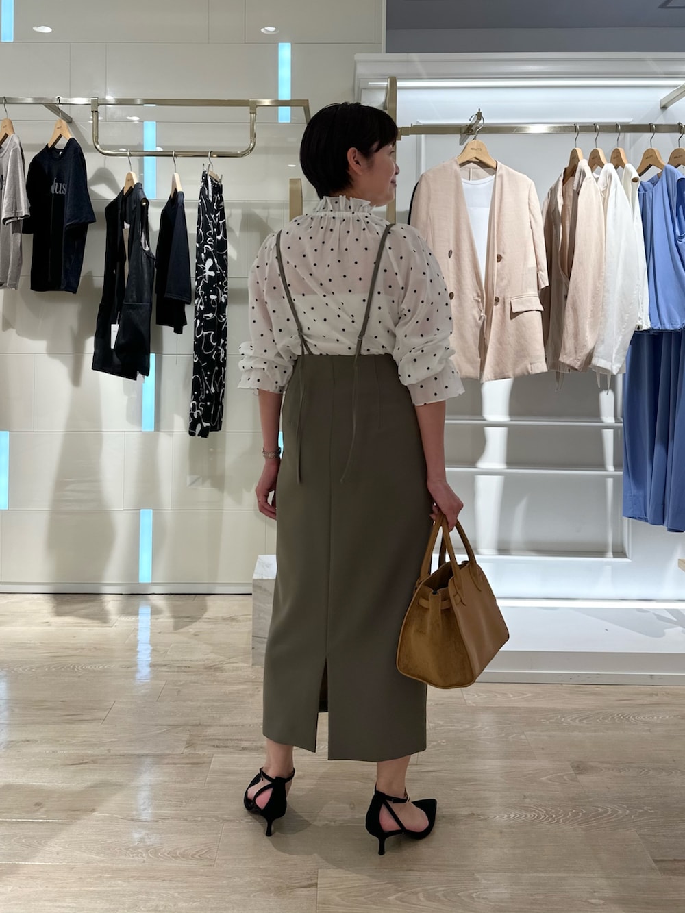 グリーン系のスカート、イエロー系のトートバッグ、ホワイト系のシャツ/ブラウスを着用したレディースの夏コーディネートの5枚目の写真