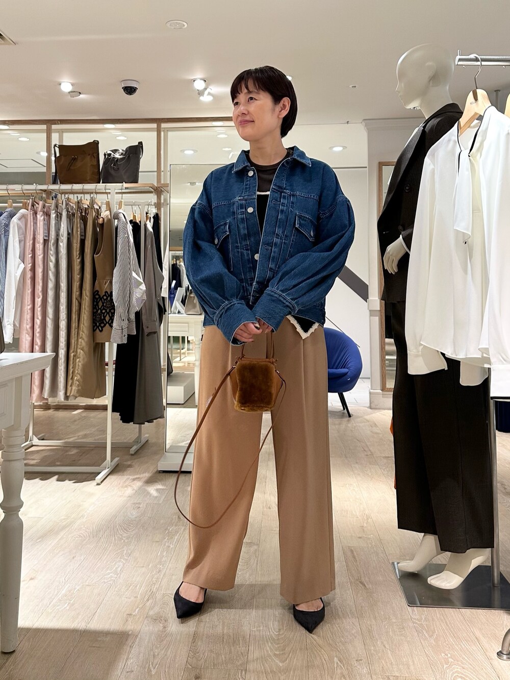 ブラック系のニット/セーター、イエロー系のショルダーバッグ、イエロー系のその他パンツを着用したレディースの秋コーディネートの6枚目の写真