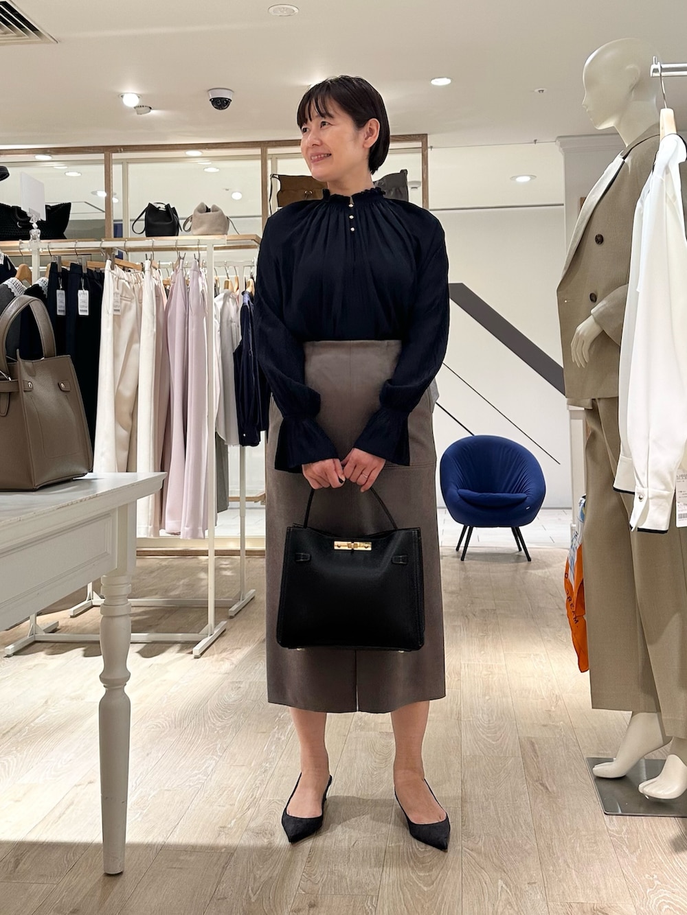 ブルー系のシャツ/ブラウス、グリーン系のスカート、ブラック系のショルダーバッグを着用したレディースの秋コーディネートの5枚目の写真