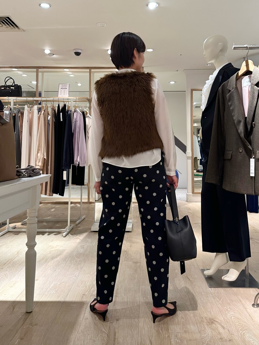 ブラック系のその他パンツ、ブラック系のショルダーバッグ、ホワイト系のシャツ/ブラウスを着用したレディースの秋コーディネートの5枚目の写真