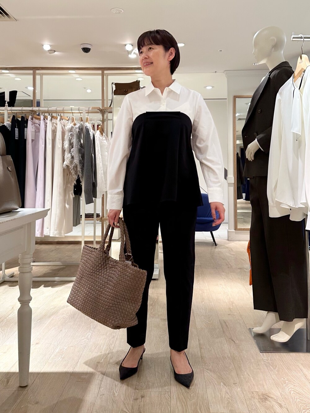 ブラック系のその他パンツ、ベージュ系のトートバッグ、ホワイト系のシャツ/ブラウスを着用したレディースの秋コーディネートの3枚目の写真