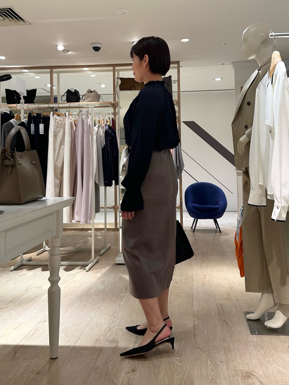 ブルー系のシャツ/ブラウス、グリーン系のスカート、ブラック系のショルダーバッグを着用したレディースの秋コーディネートの2枚目の写真