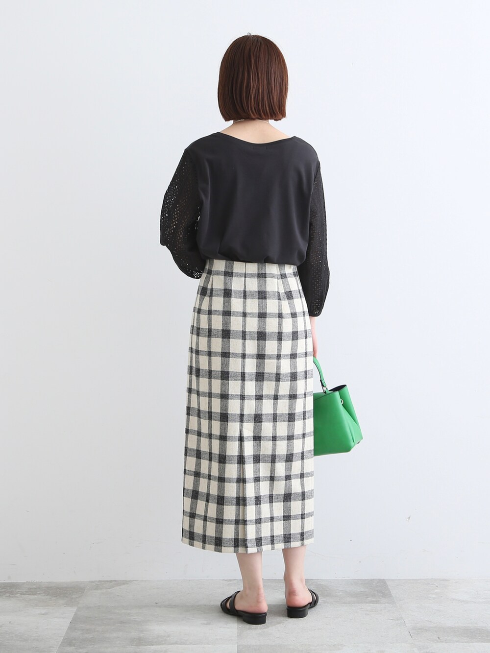 ブラック系のサンダル、ブラック系のTシャツ/カットソー、ブラック系のスカートを着用したレディースの春コーディネートの2枚目の写真