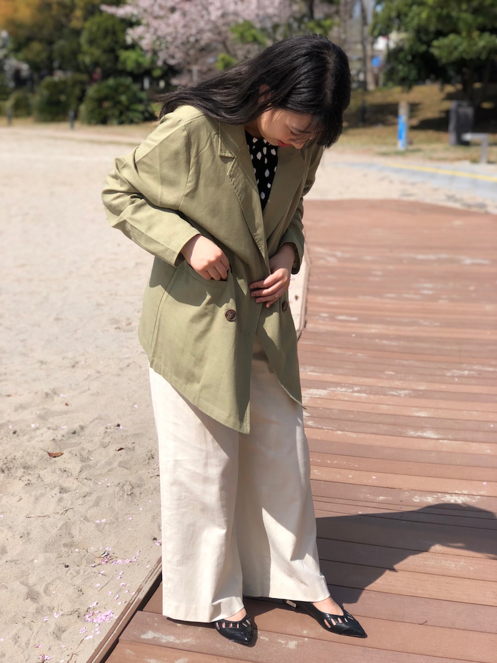 ブラック系のパンプス、ブラック系のトップス、ホワイト系のパンツを着用したレディースの春コーディネートの3枚目の写真