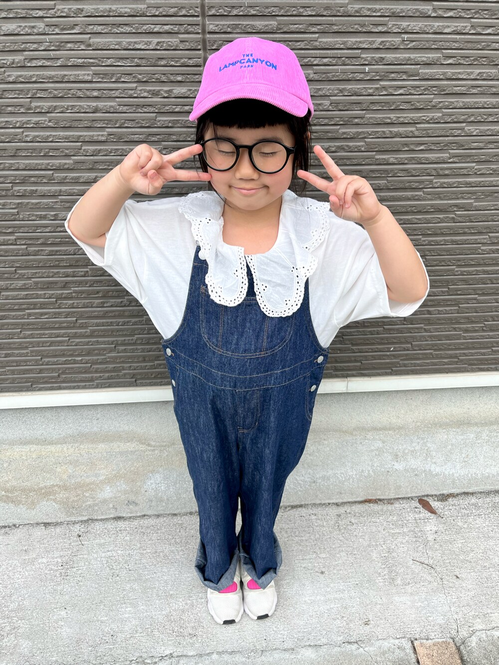 ブルー系のサロペット/オーバーオール、ホワイト系のTシャツ/カットソー、ピンク系のソックス/靴下を着用したキッズの春コーディネートの3枚目の写真