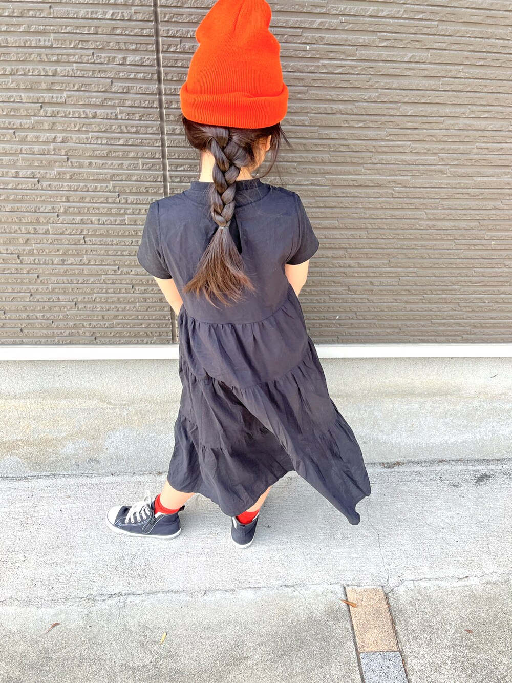 ゴールド系のバッグ、ブラック系のスニーカー、オレンジ系のニットキャップ/ビーニーを着用したキッズの春コーディネートの3枚目の写真