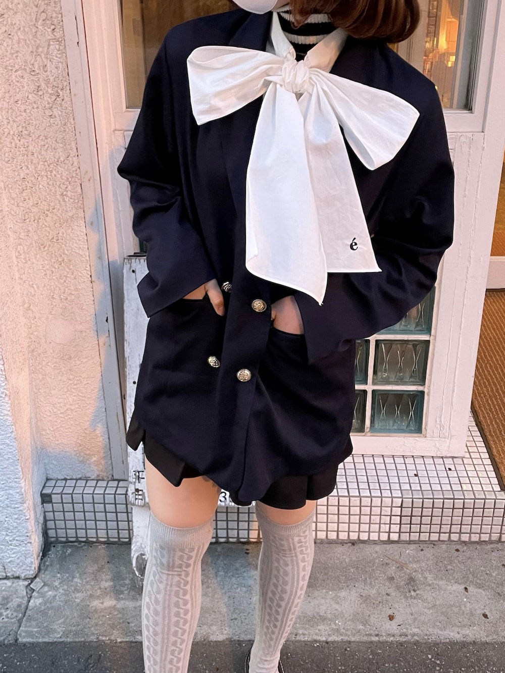 ブルー系のテーラードジャケット、ブラック系のスカート、ブラウン系のローファーを着用したレディースの春コーディネートの2枚目の写真