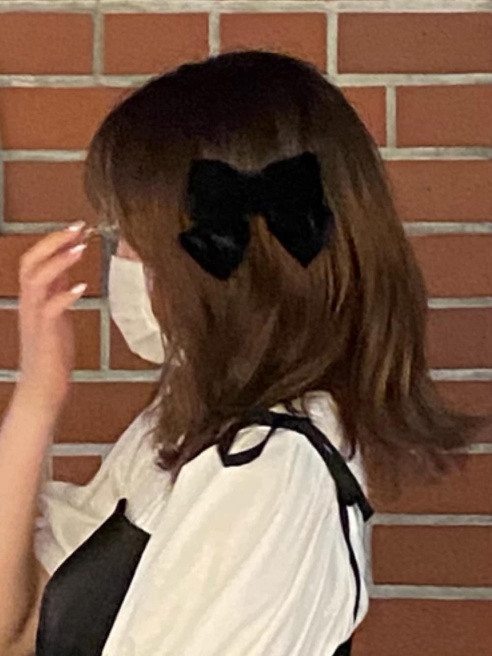 ブラック系のパンプス、ブラック系のワンピース、ベージュ系のハンドバッグを着用したレディースの秋コーディネートの3枚目の写真