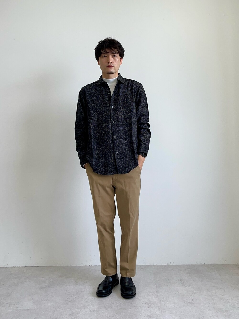 ブラック系のシャツ/ブラウス、ベージュ系のチノパンツ、ホワイト系のTシャツ/カットソーを着用したメンズの夏コーディネートの2枚目の写真