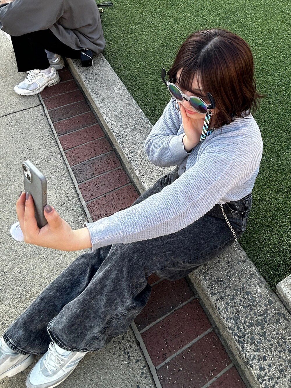 ブラック系のTシャツ/カットソー、グレー系のデニムパンツ、グレー系のカーディガン/ボレロを着用したレディースの春コーディネートの2枚目の写真