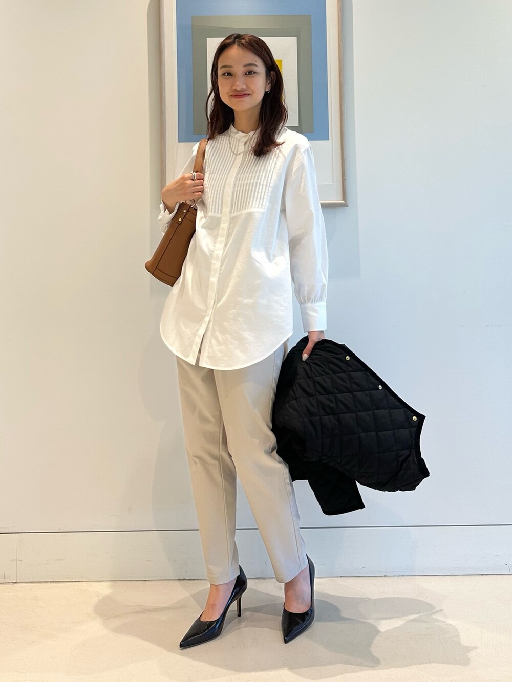 ホワイト系のシャツ/ブラウス、ブラック系のその他アウター、グレー系のスラックスを着用したレディースの秋コーディネートの2枚目の写真