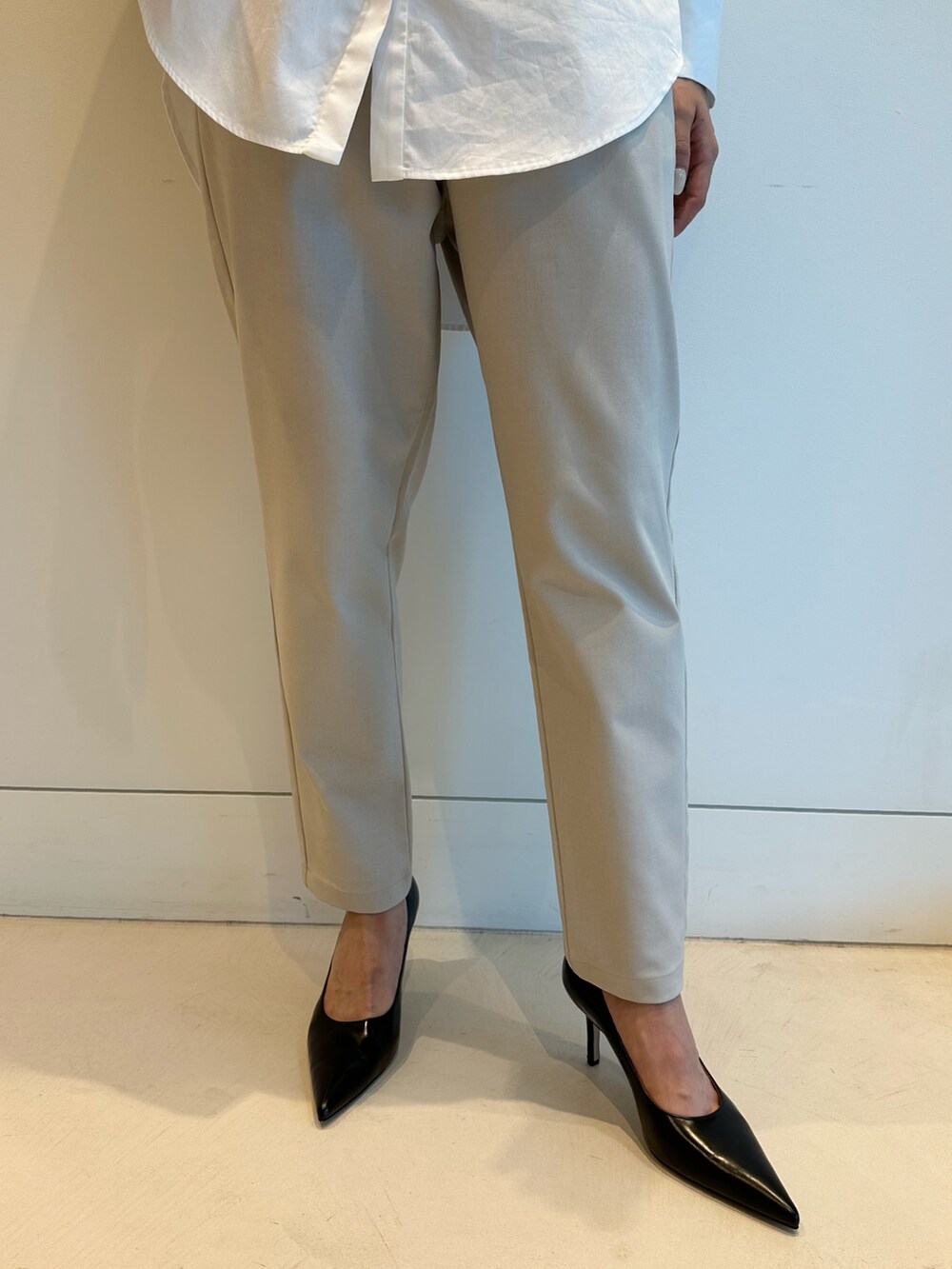 ホワイト系のシャツ/ブラウス、ブラック系のその他アウター、グレー系のスラックスを着用したレディースの秋コーディネートの4枚目の写真