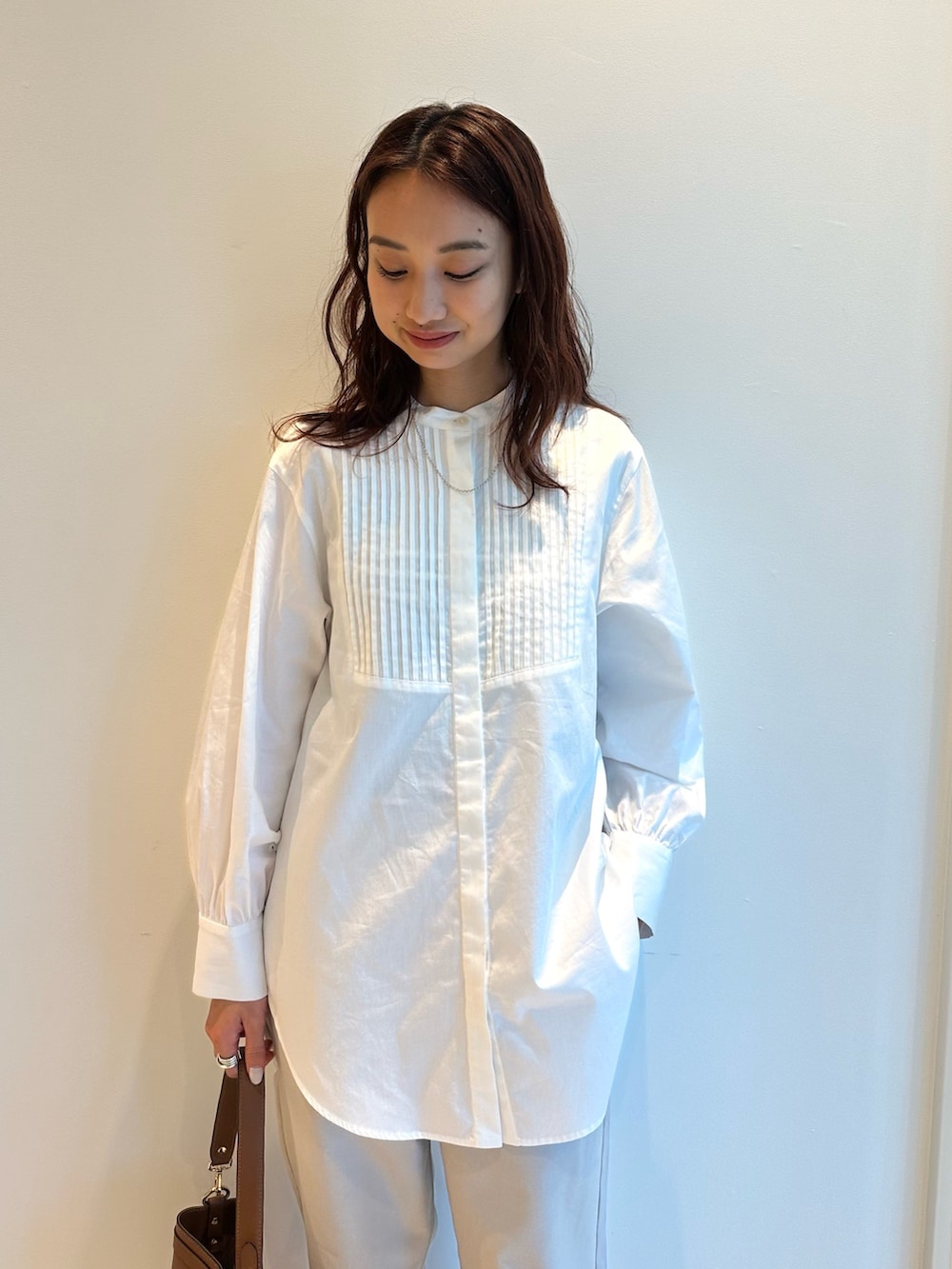 ホワイト系のシャツ/ブラウス、ブラック系のその他アウター、グレー系のスラックスを着用したレディースの秋コーディネートの3枚目の写真