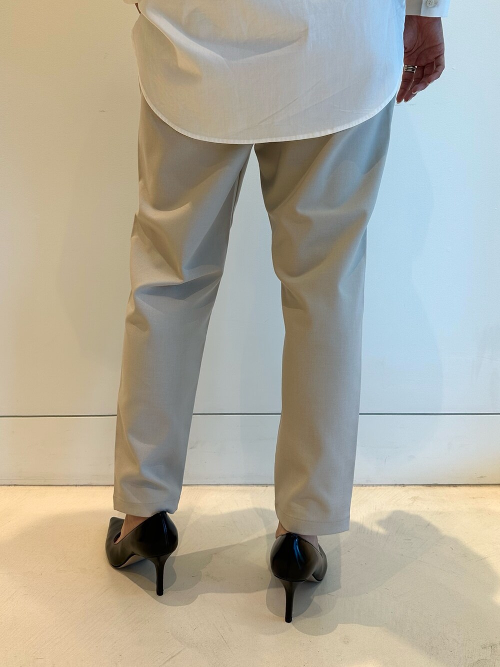 ホワイト系のシャツ/ブラウス、ブラック系のその他アウター、グレー系のスラックスを着用したレディースの秋コーディネートの5枚目の写真