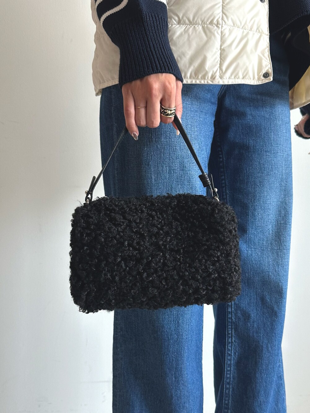 ブルー系のデニムパンツ、ブルー系のニット/セーター、ブラック系のショルダーバッグを着用したレディースの秋コーディネートの4枚目の写真
