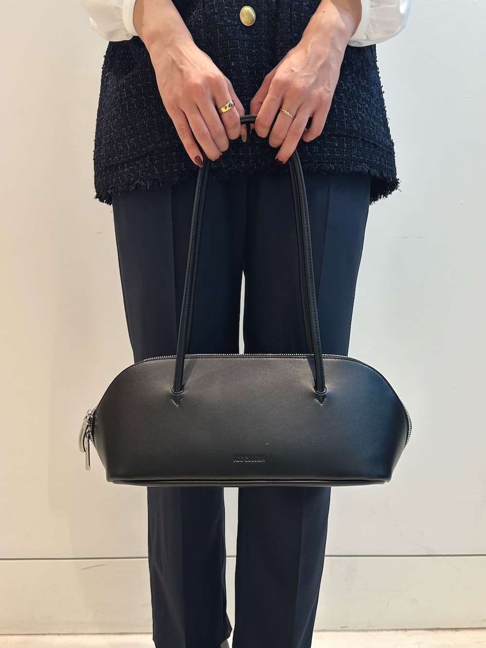 ブルー系のスーツパンツ、ブラック系のトートバッグ、ブルー系のベストを着用したレディースの秋コーディネートの6枚目の写真