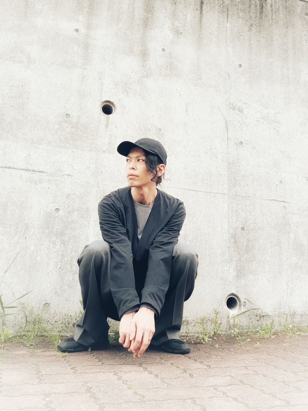 グレー系のスラックス、ブラック系のその他シューズ、ブラック系のノーカラージャケットを着用したメンズの春コーディネートの3枚目の写真