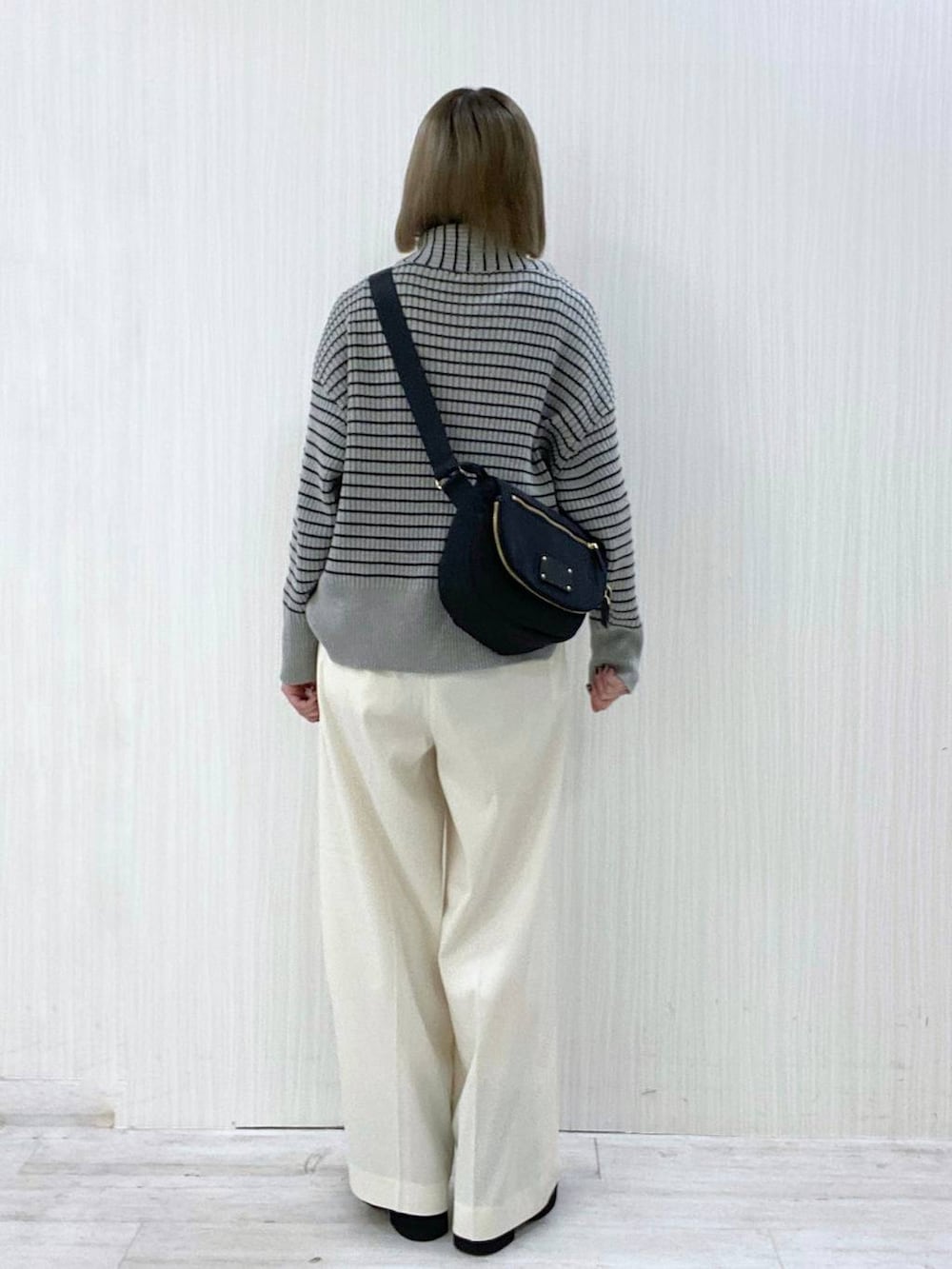 ブラック系のボディバッグ/ウエストポーチ、ホワイト系のその他パンツ、グレー系のニット/セーターを着用したレディースの秋コーディネートの3枚目の写真