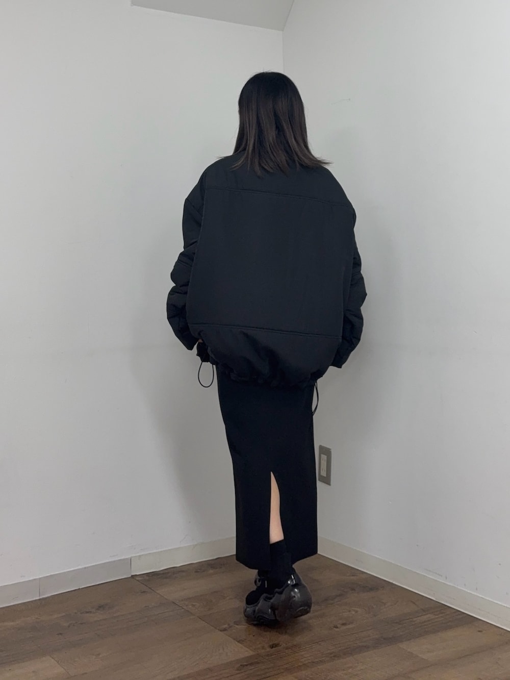 ブラック系のスカート、グレー系のスウェット、ブラック系のブルゾンを着用したレディースの冬コーディネートの3枚目の写真