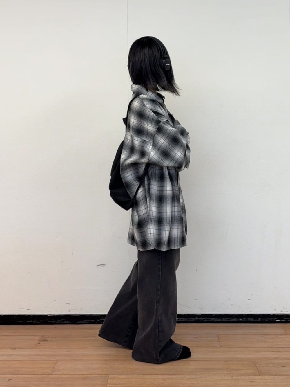 ブラック系のデニムパンツ、ブラック系のバックパック/リュック、ブラック系のシャツ/ブラウスを着用したレディースの秋コーディネートの2枚目の写真