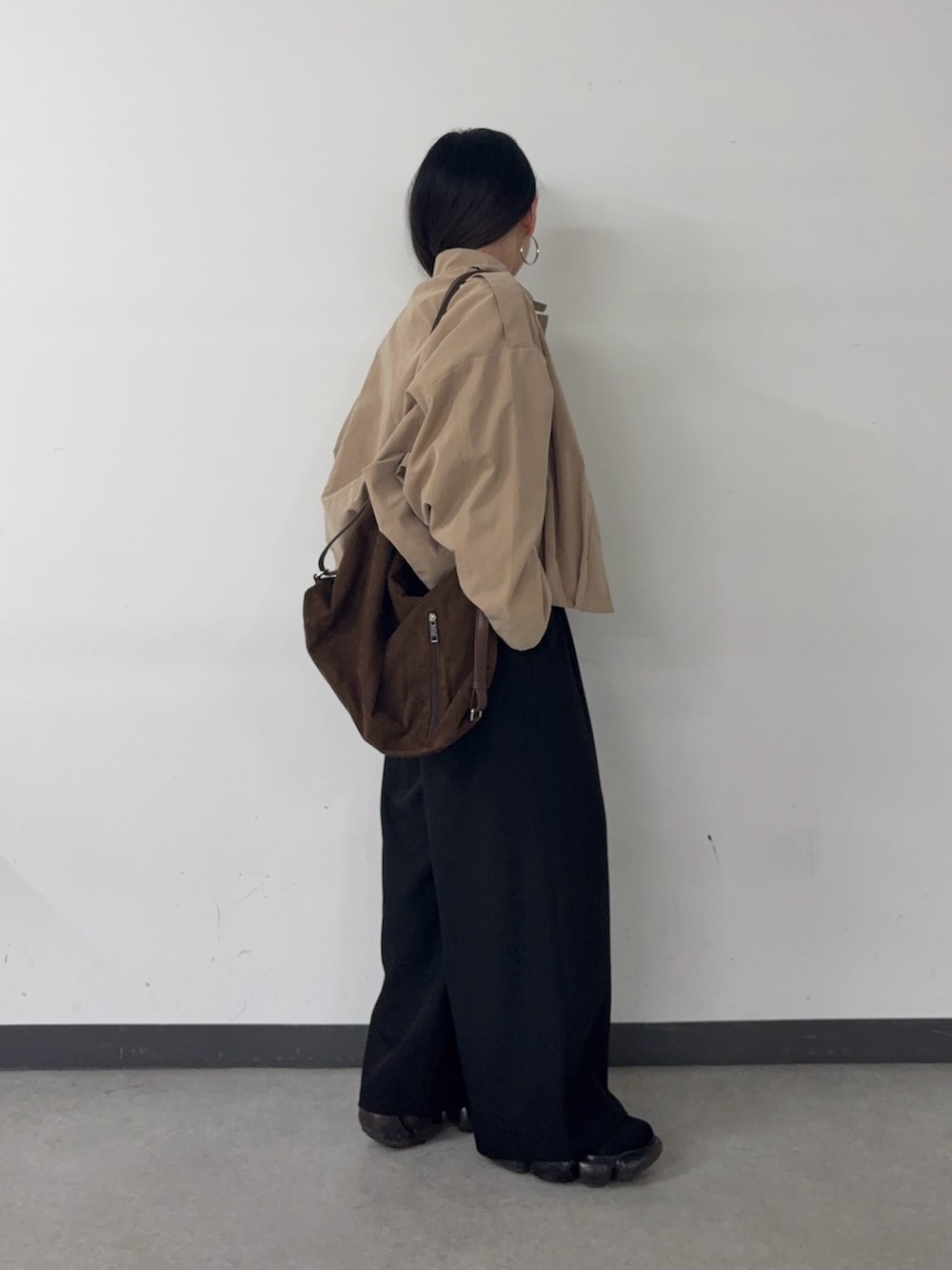 ブラック系のスラックス、ブラウン系のショルダーバッグ、イエロー系のカーディガン/ボレロを着用したレディースの春コーディネートの2枚目の写真