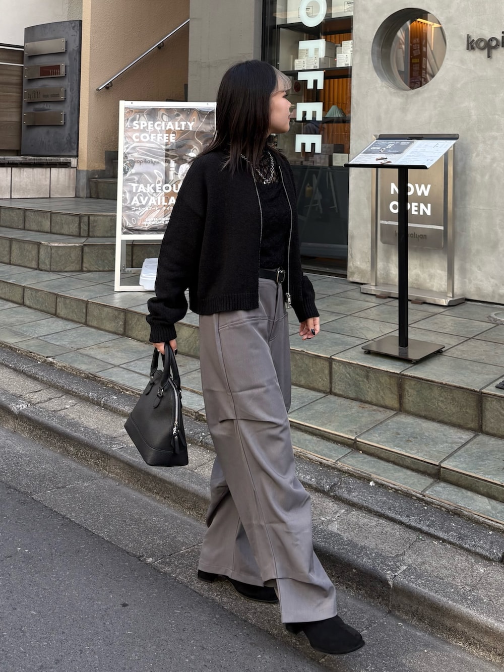 ブラック系のカーディガン/ボレロ、ブラック系のTシャツ/カットソー、ブラック系のバックパック/リュックを着用したレディースの春コーディネートの4枚目の写真