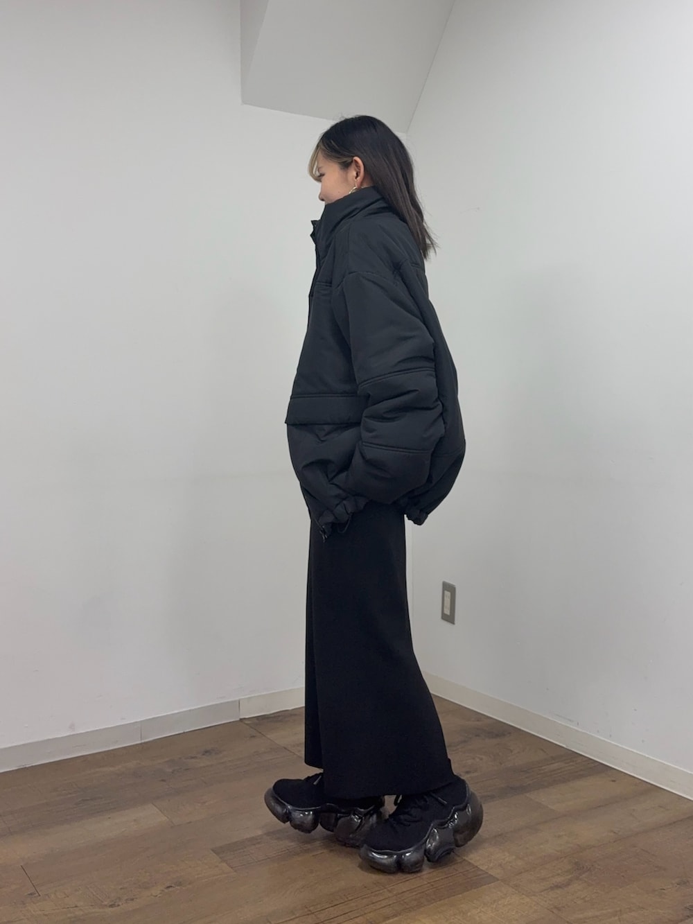 ブラック系のスカート、グレー系のスウェット、ブラック系のブルゾンを着用したレディースの冬コーディネートの2枚目の写真