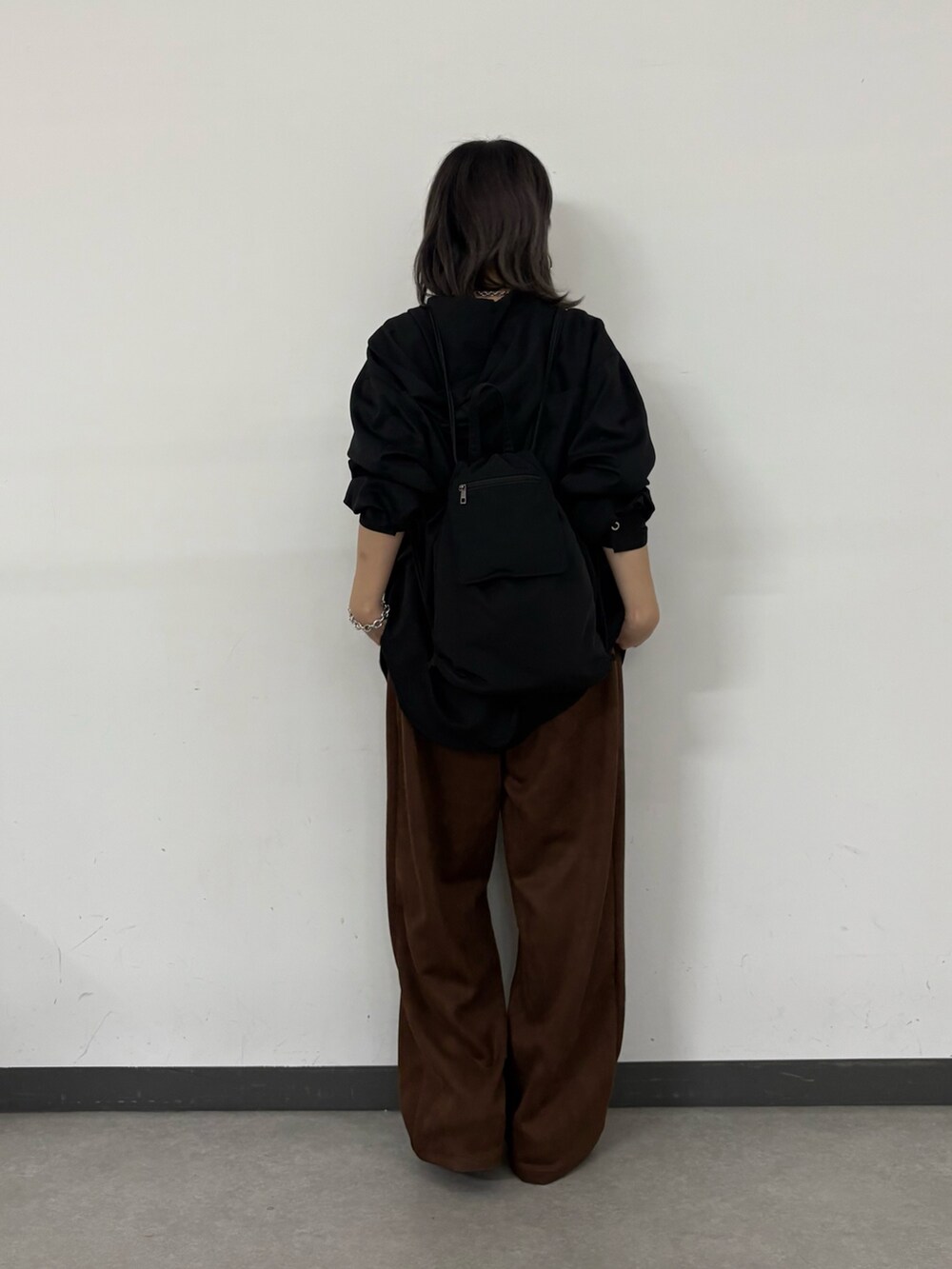 ブラック系のシャツ/ブラウス、シルバー系のシャツ/ブラウス、ブラック系のバックパック/リュックを着用したレディースの秋コーディネートの3枚目の写真