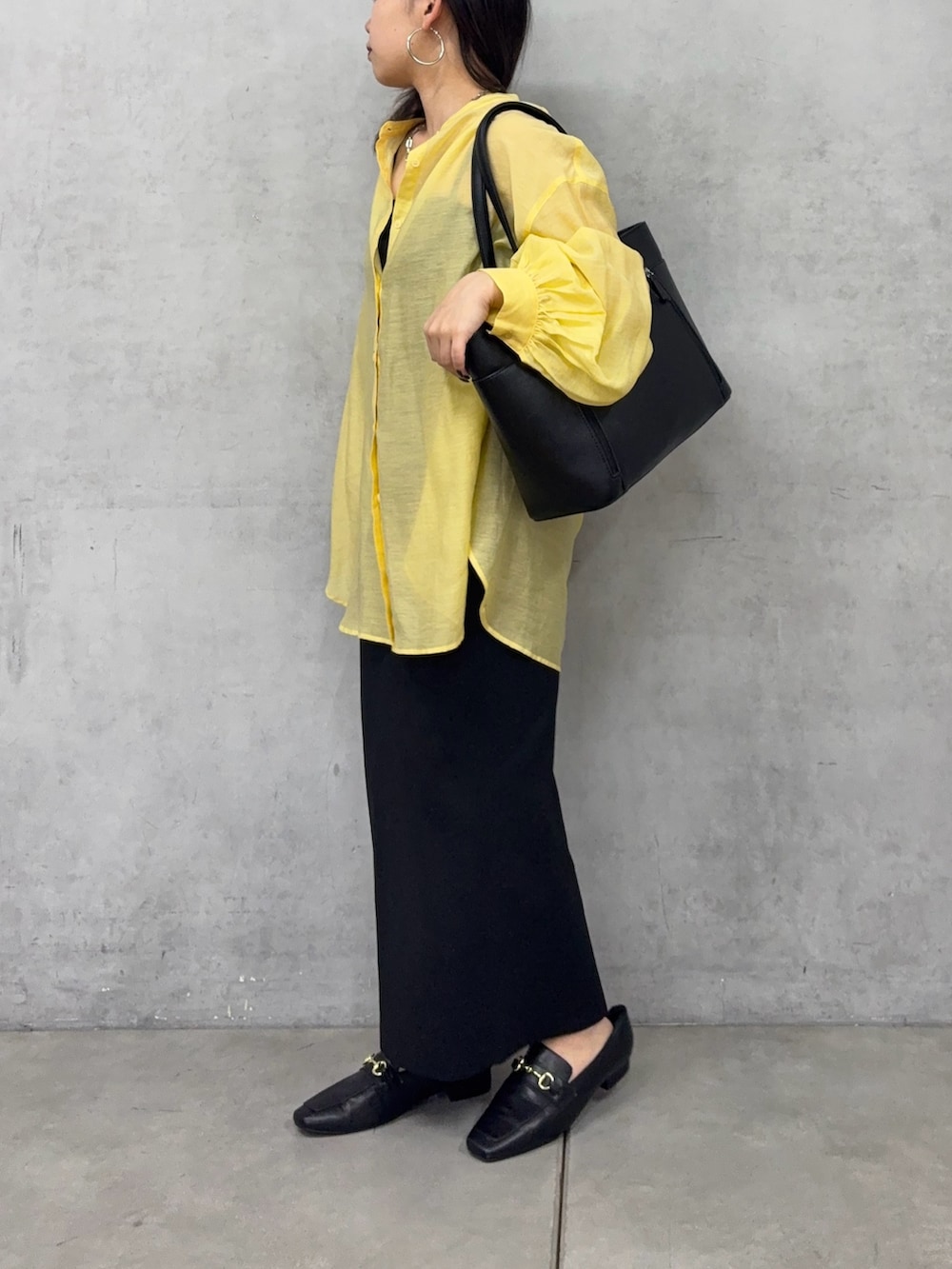 ブラック系のトートバッグ、ブラック系のスカート、ブラック系のシャツ/ブラウスを着用したレディースの春コーディネートの2枚目の写真