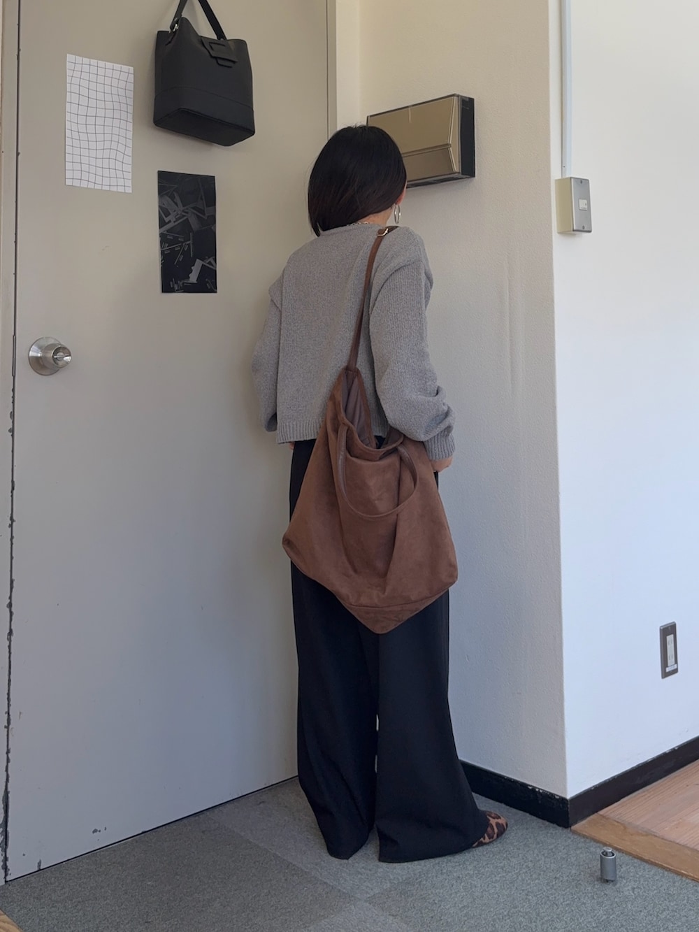 ブラック系のスラックス、その他のバレエシューズ、ブラウン系のトートバッグを着用したレディースの春コーディネートの3枚目の写真