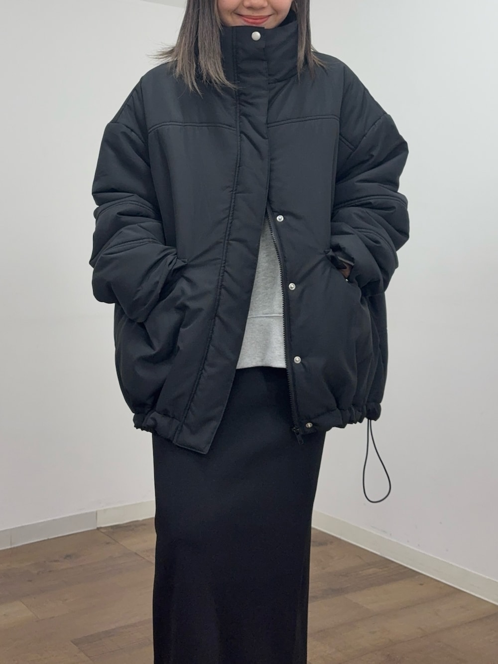 ブラック系のスカート、グレー系のスウェット、ブラック系のブルゾンを着用したレディースの冬コーディネートの4枚目の写真