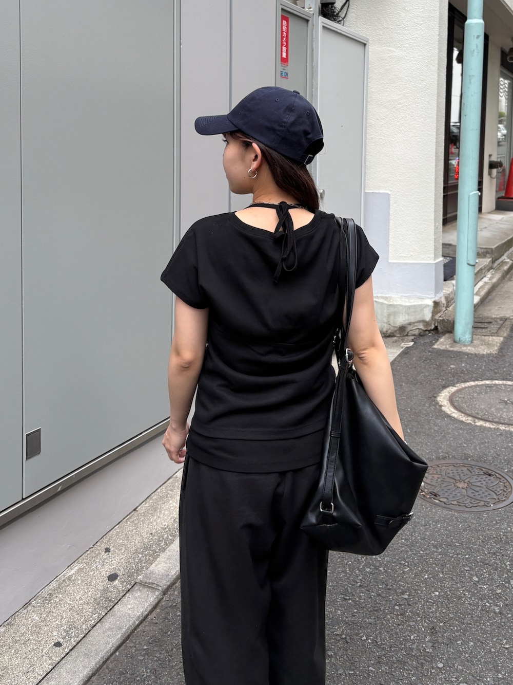 ブラック系のTシャツ/カットソー、ブラック系のショルダーバッグ、ブラック系のスラックスを着用したレディースの夏コーディネートの3枚目の写真