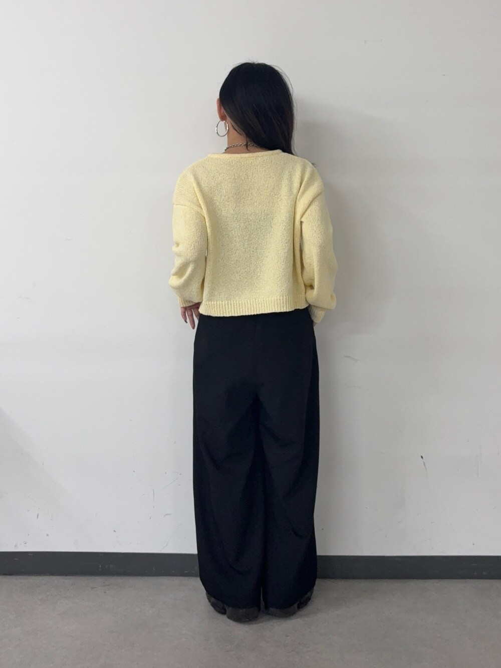 グレー系のスラックス、イエロー系のカーディガン/ボレロを着用したレディースの春コーディネートの3枚目の写真