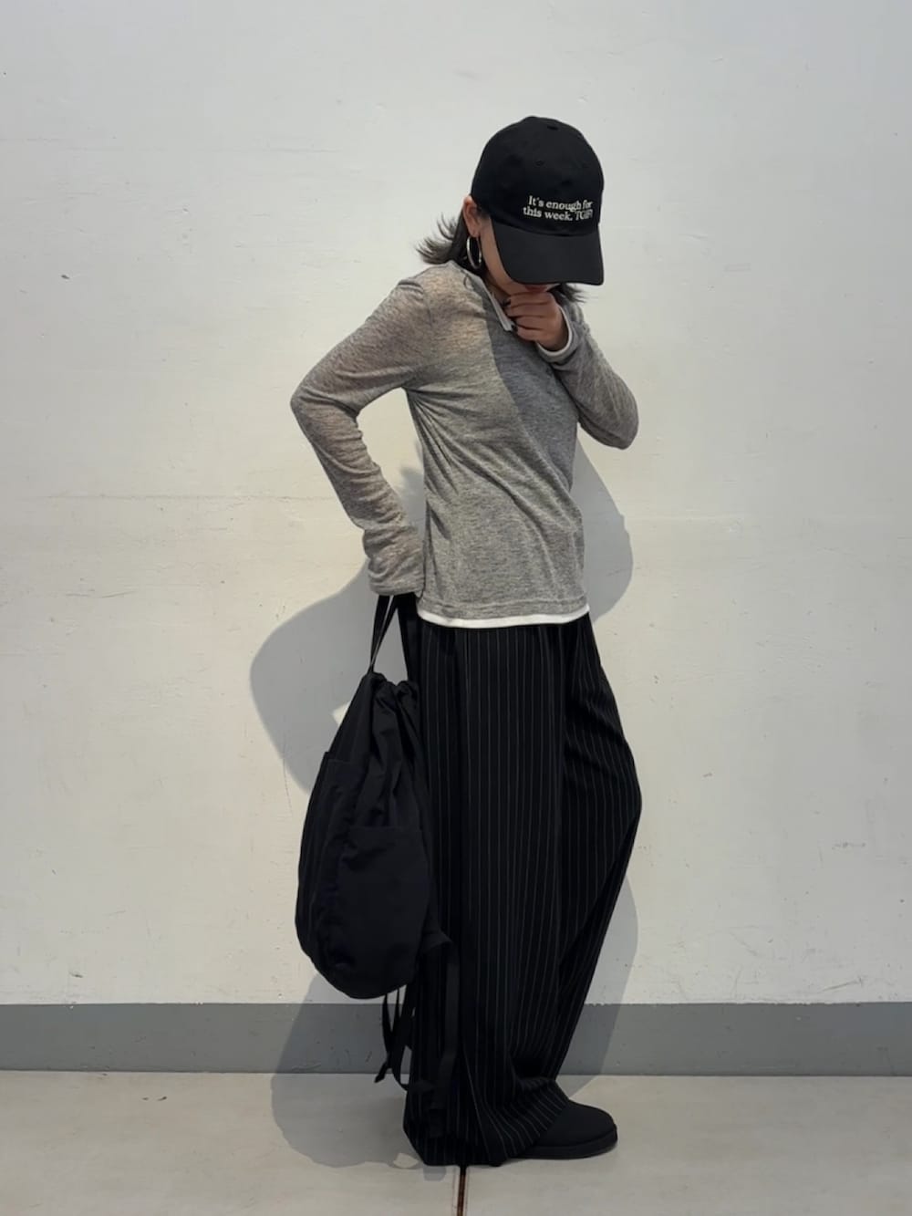 グレー系のTシャツ/カットソー、ブラック系のバックパック/リュック、ブラック系のスラックスを着用したレディースの秋コーディネートの4枚目の写真
