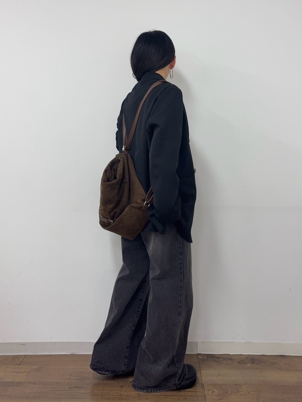 ブラック系のデニムパンツ、ブラック系のサンダル、ブラック系のテーラードジャケットを着用したレディースの冬コーディネートの2枚目の写真