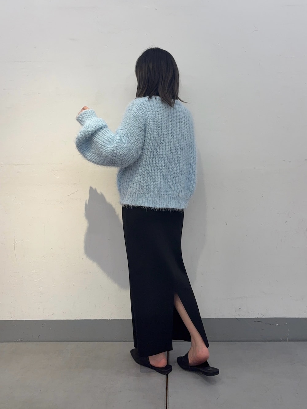 ブラック系のスカート、ブラック系のサンダル、ブラック系のショルダーバッグを着用したレディースの冬コーディネートの3枚目の写真