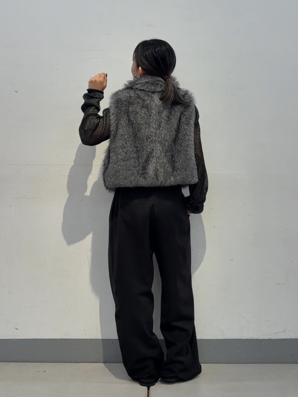 ブラック系のスラックス、シルバー系のシャツ/ブラウス、ブラック系のサンダルを着用したレディースの秋コーディネートの3枚目の写真