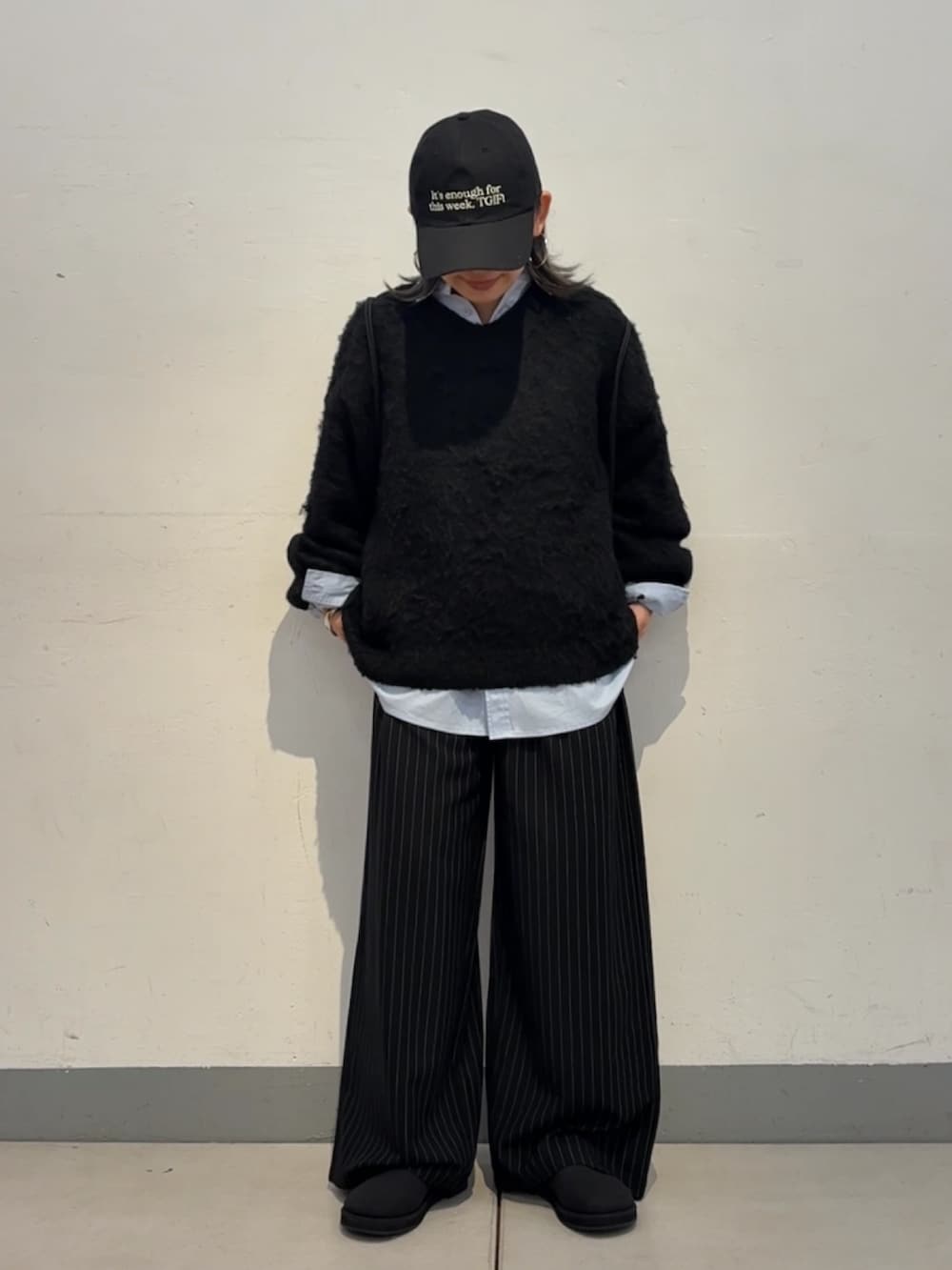 ブラック系のニット/セーター、ブルー系のシャツ/ブラウス、ブラック系のサンダルを着用したレディースの秋コーディネートの4枚目の写真