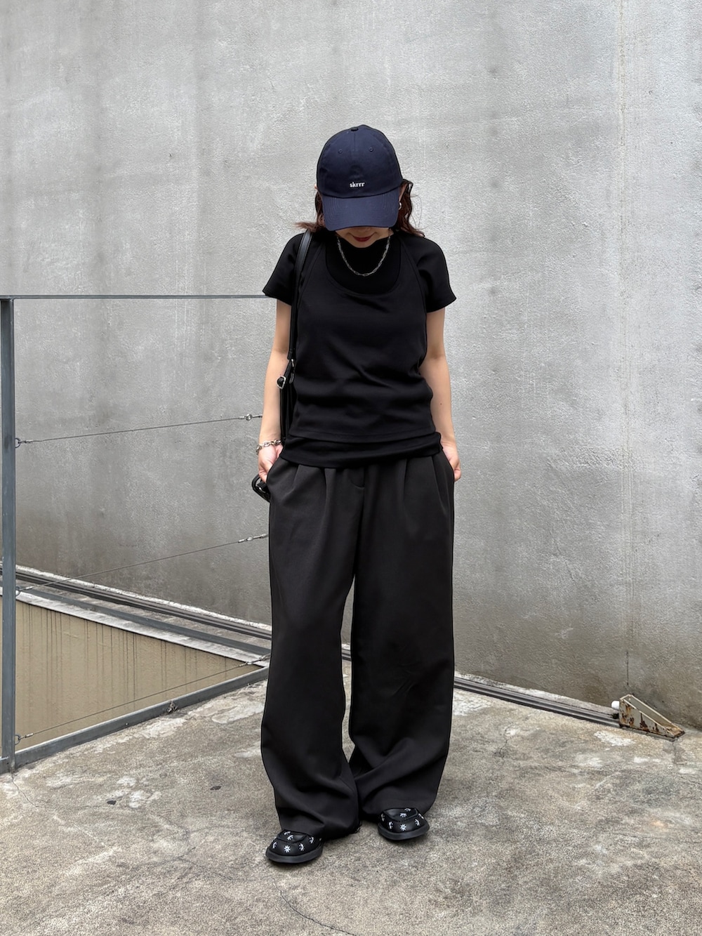 ブラック系のTシャツ/カットソー、ブラック系のショルダーバッグ、ブラック系のスラックスを着用したレディースの夏コーディネートの2枚目の写真